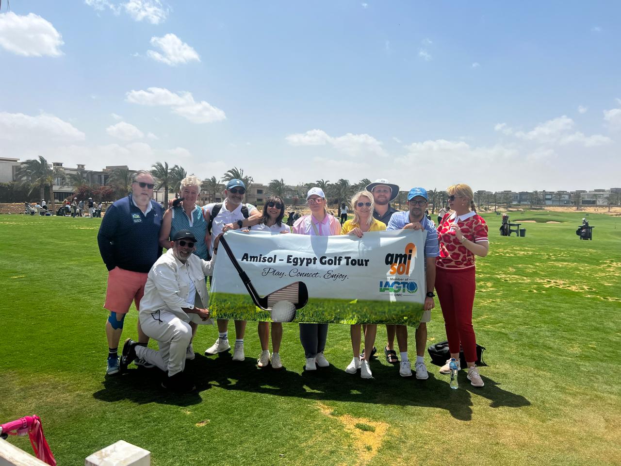 Tour operator group holding the Amisol Egypt Golf Tour banner on a Cairo fairway