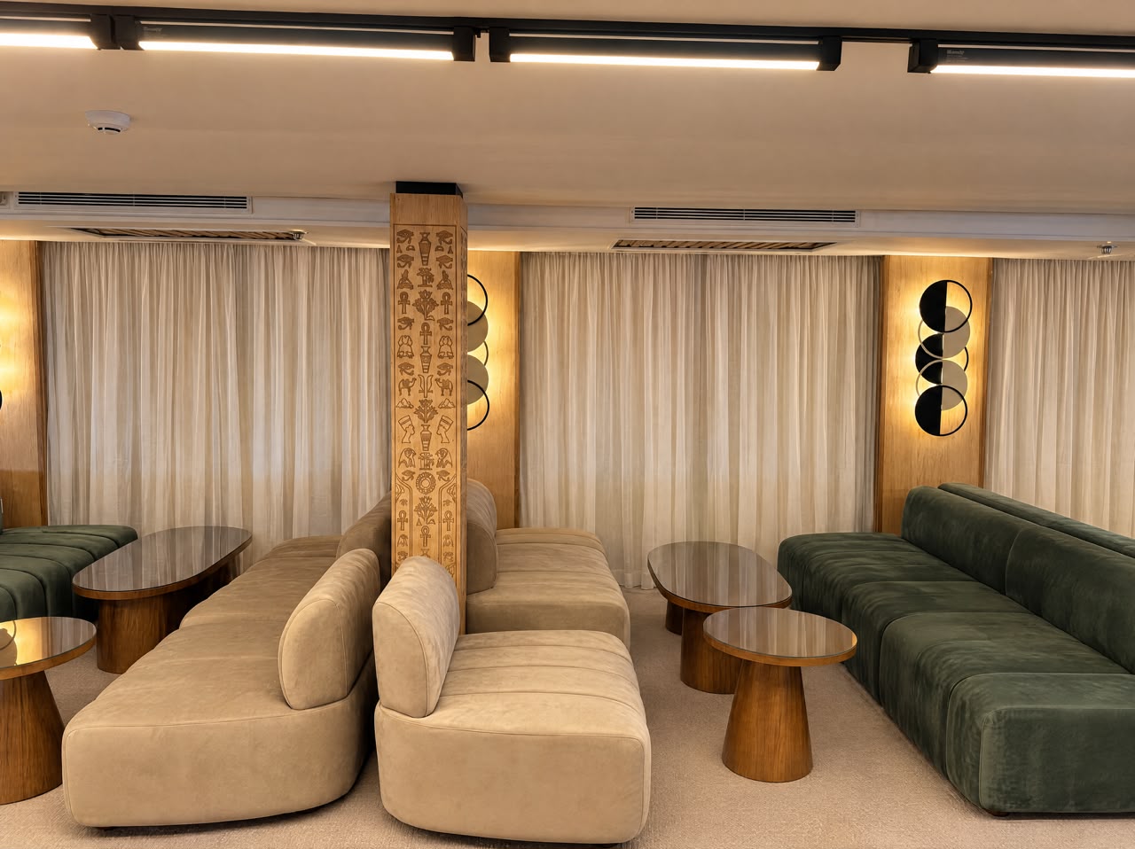 Carved hieroglyph column between sand-toned armchairs in the Moletnela lounge