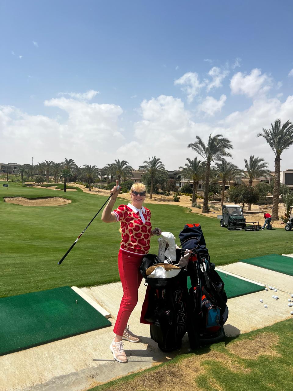 Golfer at the driving range beside palm-lined fairways in Egypt