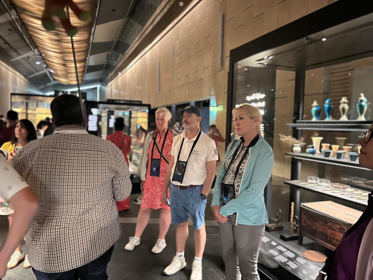 Tour operators viewing ancient Egyptian artefact cases at the Grand Egyptian Museum
