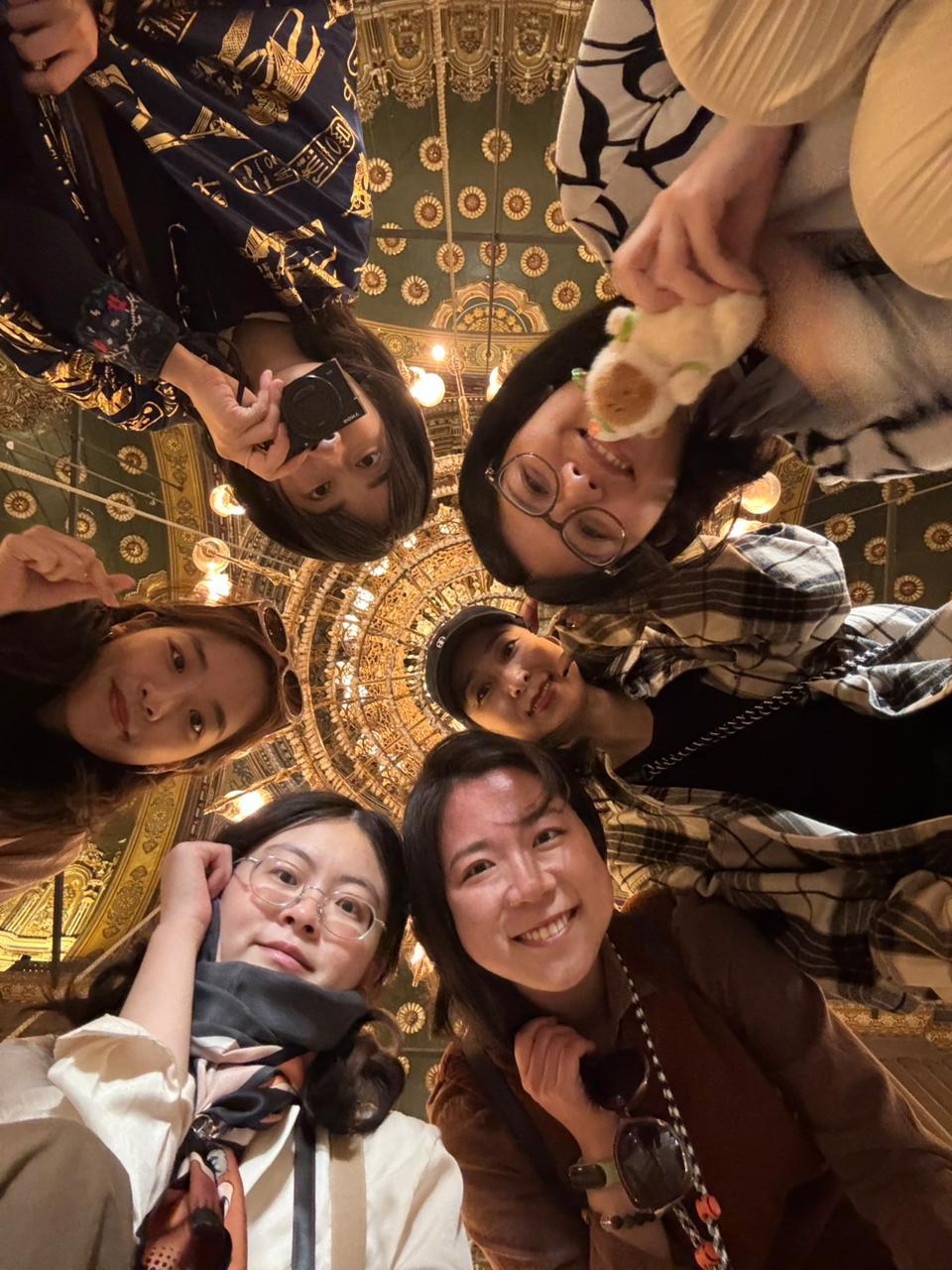 Chinese travellers looking up at the ornate dome of a historic Egyptian mosque