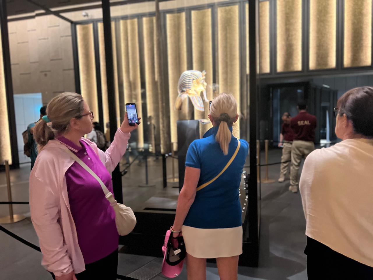 Travel partners photographing the Tutankhamun mask at the Grand Egyptian Museum