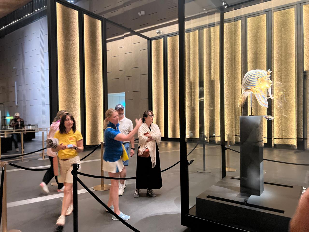 FAM trip group beside the golden mask of Tutankhamun at the Grand Egyptian Museum