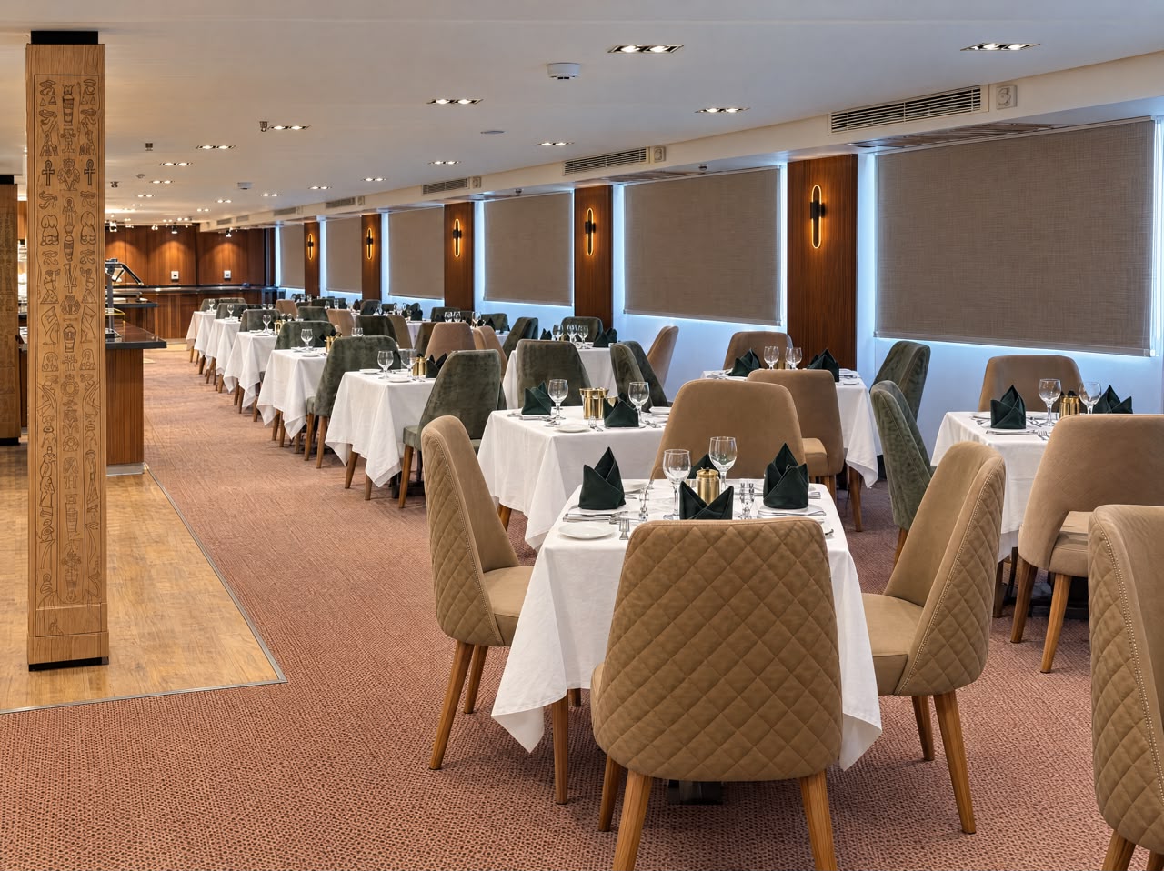 Main restaurant dining room with white linen tables and hieroglyph columns, representative imagery of Q Nile