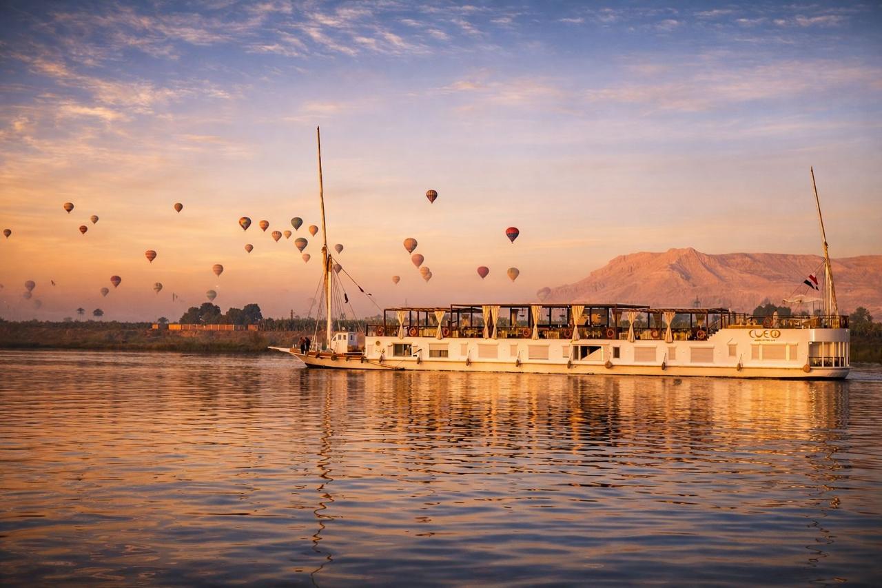 Cleo Dahabiya sailing on the Nile between Luxor and Aswan at sunrise with hot-air balloons over the West Bank